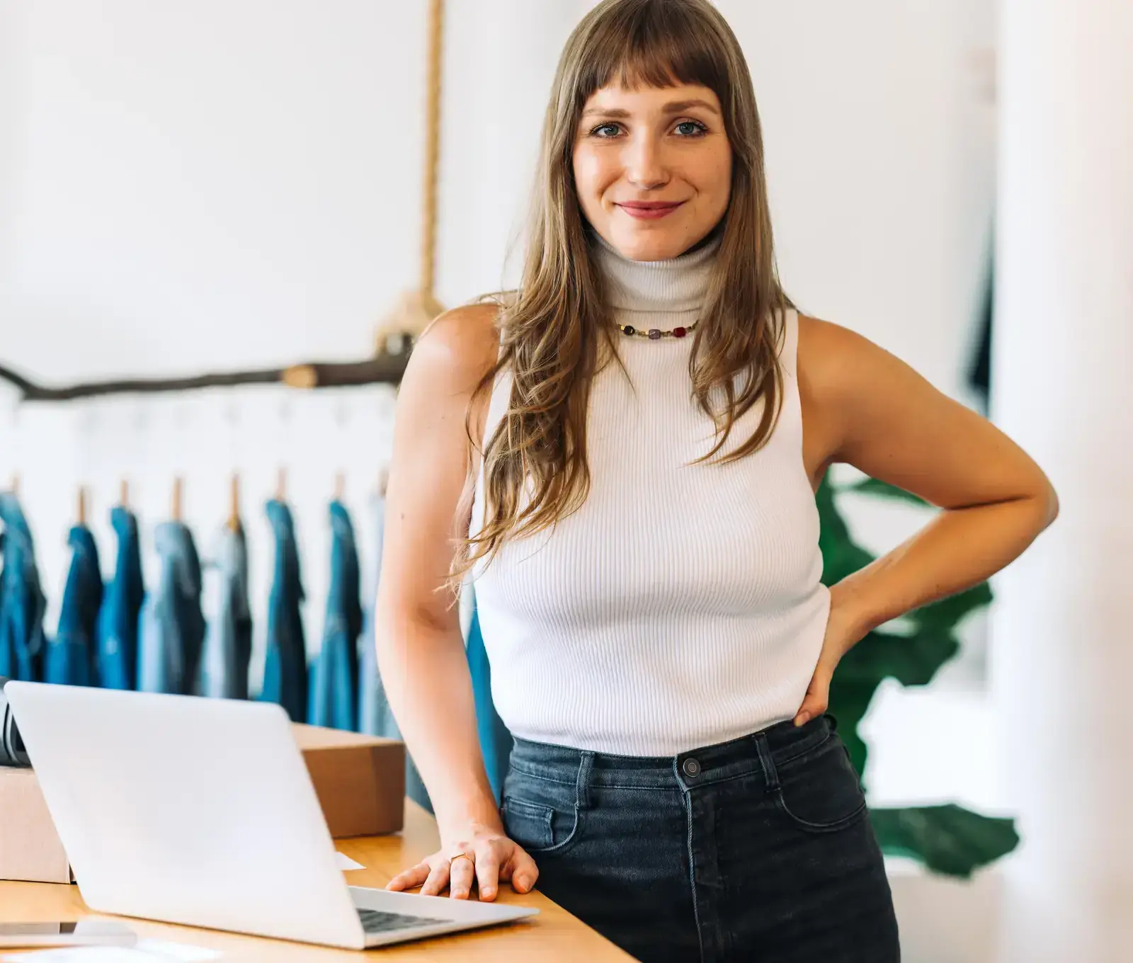 Small business owner standing at her laptop in her shop